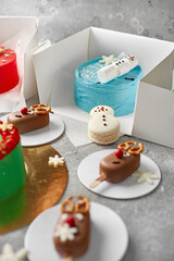 Obraz na płótnie Canvas Christmas sweet cake. sweet deer, snowflakes, sweet snowman on a concrete background.