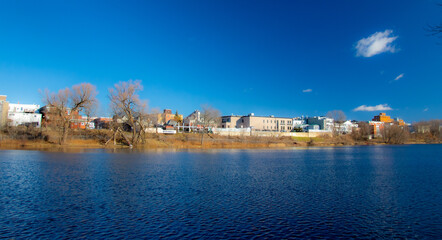 View of the backyard of the buildings on the main street of Magog from the other side of the river