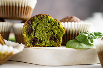 Spinach muffins. Half of a green muffin with fresh spinach leaves. Home baking.