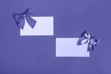 Blank card with a red and silver bow on a very peribackground. The concept of postcards, business cards. With copy space