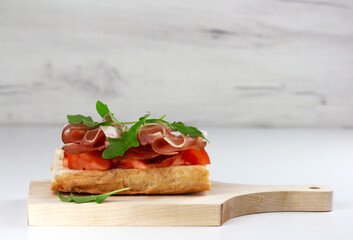 Tapas with spanish hamon or bruschetta with italian proscuitto on wooden board
