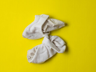 crumpled white dirty socks on yellow background