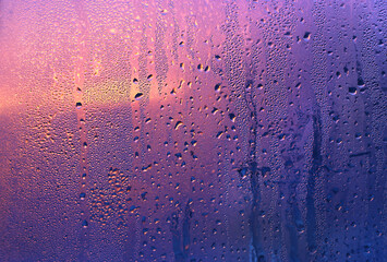 Water drops and sunlight on glass, close-up natural texture