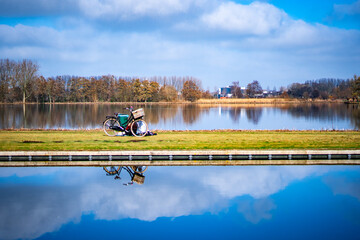 Piknik nad wodą, rower z koszykiem piknikowym. Piękna słoneczna pogoda idealna na odpoczynek nad wodą.