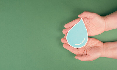 Hands holding a drop of water, paper cut out, environmental issue, copy space for text