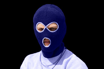 Closeup headshot of criminal wearing very pery balaclava and hoodie looking at camera, copy space, isolated over black background. very peri colored. Color of the year 2022