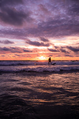 silhouette of a surfer in the sunset