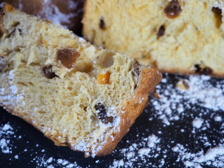 Delicious slices of Panettone with candied fruit and raisins, sprinkled with powdered sugar. Close-up