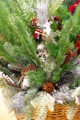 Basket with Christmas decorations. Twigs of green Christmas trees with cones and toys