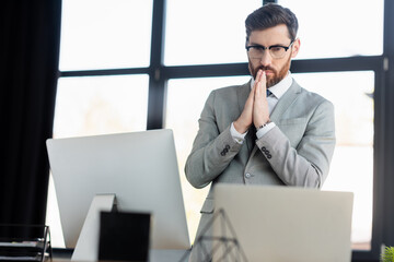 Focused businessman looking at computers in office.