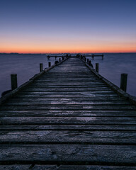 Obraz premium Holzsteg im Olgahafen am Dümmer kurz vor Sonnenaufgang zur blauen Stunde