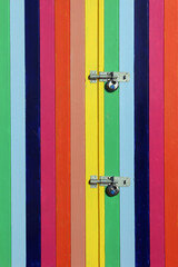 Multicolor painted wooden door planks with metal padlocks, (texture, background)