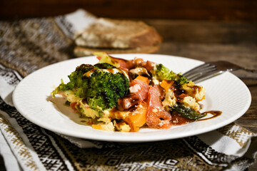 Dish, salmon with vegetables on a white plate on a kitchen napkin on a wooden dining table .. Home cooking.
