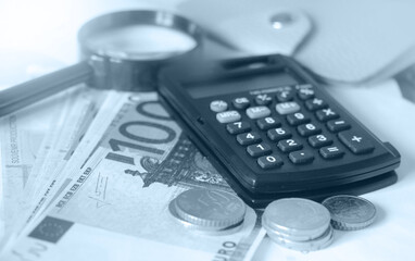 Euro banknotes, coins, wallet and magnifier. Money, salary concept. Blue duotone