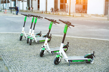 There are many electric scooters parked on the street. A new trend in urban mobility © Vladyslav