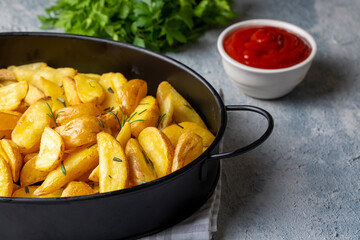 Roasted potato wedges with herbs and sea salt on plate, top view (Turkish name; elma dilim patates)