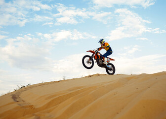Fototapeta na wymiar Motorcross riding over sand in desert dune