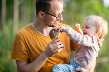 Father and a baby daughter during mushroom picking