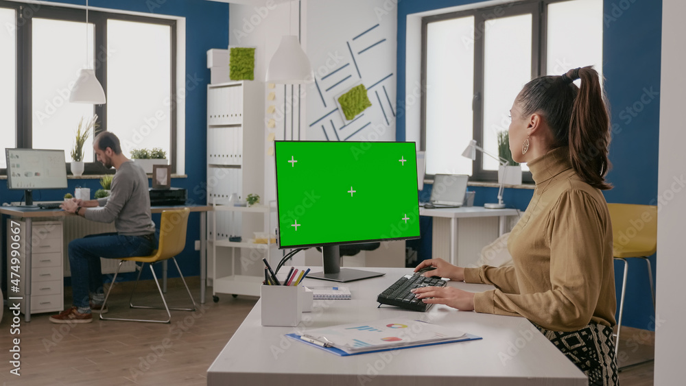 Aufkleber woman using computer with isolated green screen at desk. person working with chroma key and mock up 