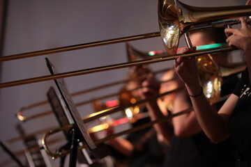 A group of brass band players playing together on golden musical instruments trumpet trombone...
