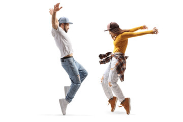 Full length profile shot of a female and male dancer in casual clothes dancing on tiptoes