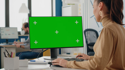 Close up of woman using computer with isolated green screen on display. Company worker looking at...