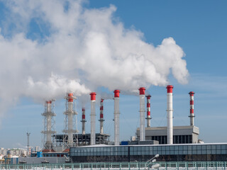 Several chimneys of the heating plant are releasing plumes of steam or white smoke. Heating of...