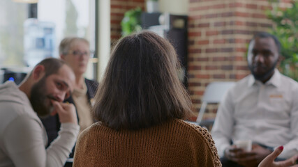 Close up of woman sharing addiction story to people in circle at aa group meeting. Person having...