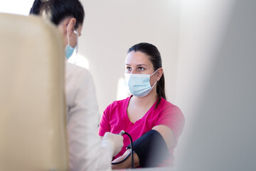 Female medicine doctor measuring blood pressure to patient