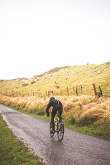 Fototapeta premium Young caucasian man going downhill with a road bike on an asphalt road of a mountain.