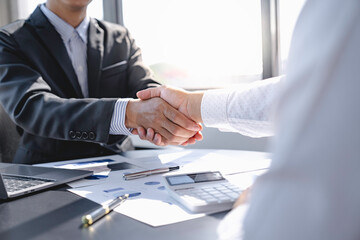 Business people shaking hands in office for teamwork of business merger and acquisition,successful negotiate,two businessman shake hand with partner to celebration partnership and business deal