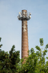 Brick high chimney with transmitters on top.