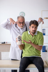 Obraz premium Young male patient visiting old male doctor in expensive medicin