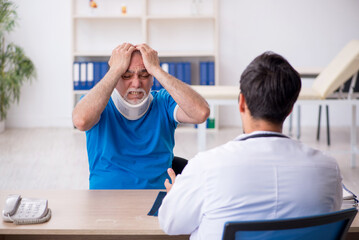 Obraz premium Old neck injured male patient visiting young male doctor