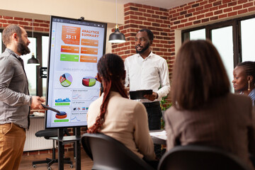Diverse entrepreneurs analyzing financial statistics working at business presentation during...