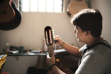 latin man arranging the pins of a stringed instrument in his repair shop
