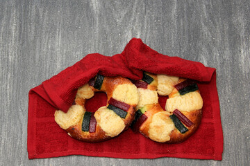 The roscón, rosca de Reyes or king cake, a torus-shaped sweet dough bun decorated with slices of candied or crystallized fruit of various colors, are placed inside ceramic or plastic figurines
