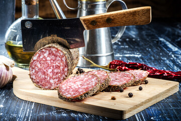 pieces of salami sausage and hatchet knife.