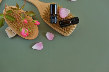 Obraz na płótnie Canvas Rose oil .Aromatherapy and cosmetics. Glass bottles,rose flowers on green background.Organic natural rose oil.Organic cosmetics