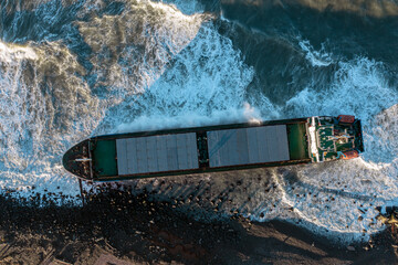 A large seagoing vessel dry cargo ship washed ashore during a strong storm wind and ran aground....