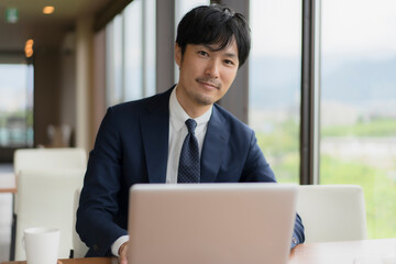 カフェでスーツ姿の男性とPC
