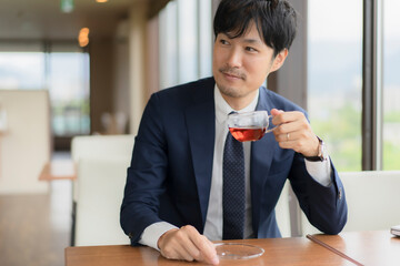 カフェでスーツ姿の男性とPC
