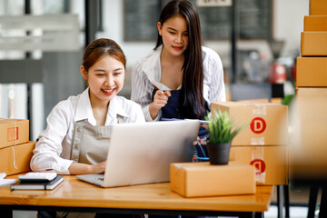 Two Asian young woman working together for SME project. Young Owner people startup for Business Online, SME, Delivery Project. Online Business and  Small business Concept