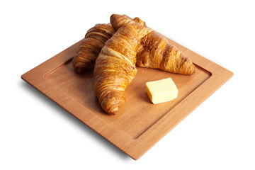 Breakfast croissants on a wood board with butter