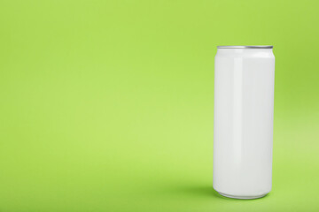 White can of energy drink on green background. Space for text