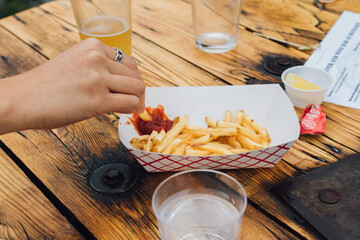 hand picking at French fries outdoors at brewery 