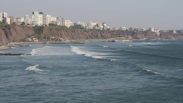 Aerial image of people practicing surfing on the beaches of Miraflores, Lima, Peru.