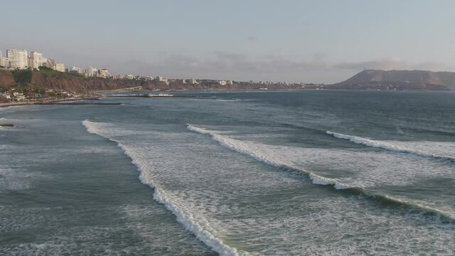 Aerial image of people practicing surfing on the beaches of Miraflores, Lima, Peru.