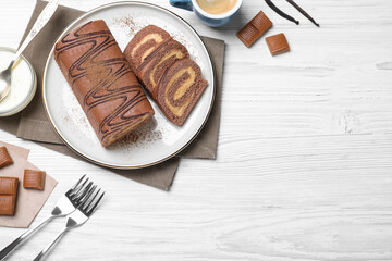 Tasty chocolate cake roll with cream on white wooden table, flat lay. Space for text