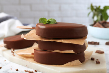 Delicious glazed ice cream bars with mint on board, closeup